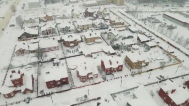 Kar fırtınasından sonra karla kaplı bir banliyöde tek katlı evler.