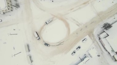 Tipiden sonra yoğun beyaz karla kaplı yuvarlak bir yoldaki arabalar..