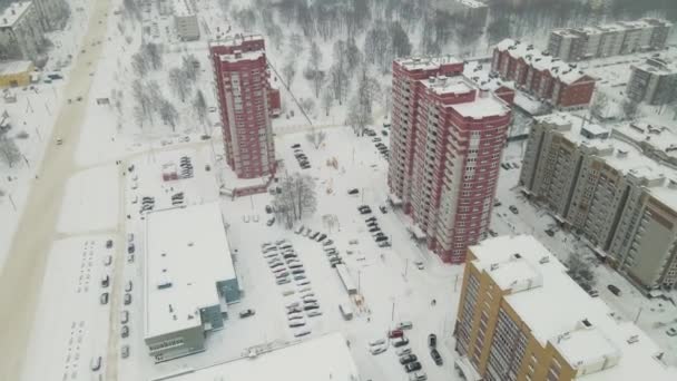 Edificios residenciales de gran altura y una carretera de la ciudad están cubiertos de nieve blanca. — Vídeo de stock