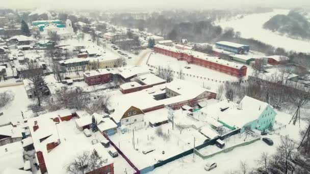 Hermosa ciudad cubierta de nieve en la orilla del río, paisaje de invierno, vista aérea. — Vídeos de Stock