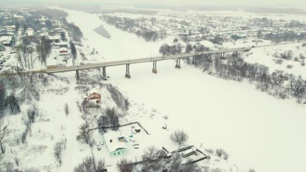 Eine märchenhafte schneebedeckte Landschaft, Blick in die Luft, eine Brücke und ein gefrorener Fluss — Stockvideo