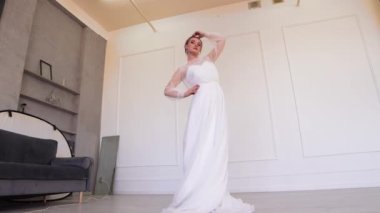 Beyaz elbiseli güzel gelin, fotoğrafçıya poz veriyor..