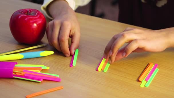 Ученик в классе или дома учится математике с помощью палочек для подсчета. — стоковое видео