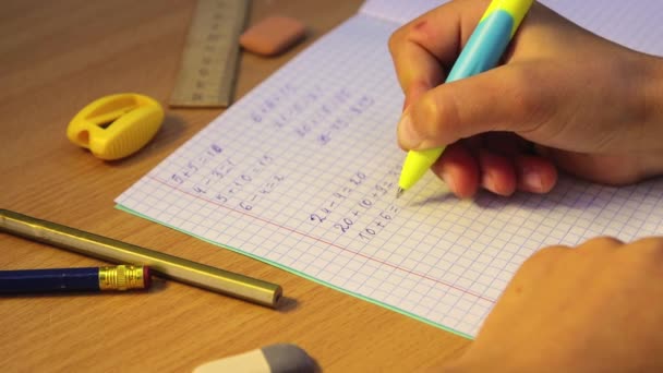 Bir lise öğrencisinin elleri matematik örneklerini bir defterde çözer.. — Stok video
