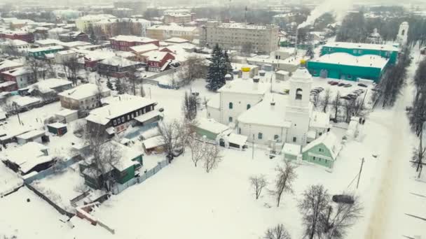 Frumos oraș acoperit cu zăpadă și biserică, peisaj de iarnă, vedere aeriană. — Videoclip de stoc