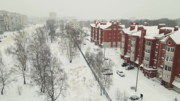Трехэтажные кирпичные дома на городской улице, покрытой снегом зимой. — стоковое видео