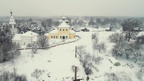 Dramatic snowy rural landscape and church, winter, aerial view. — Stock Video