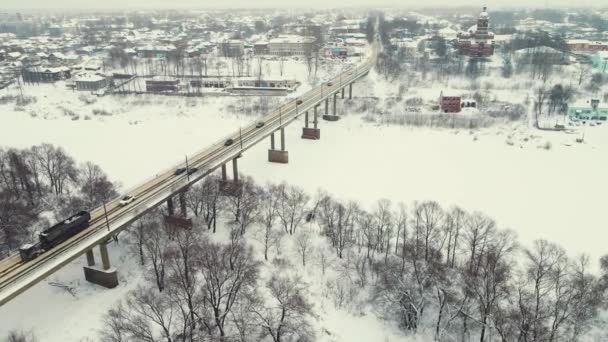 Драматический зимний пейзаж, вид с воздуха, мост и замерзшая река. — стоковое видео