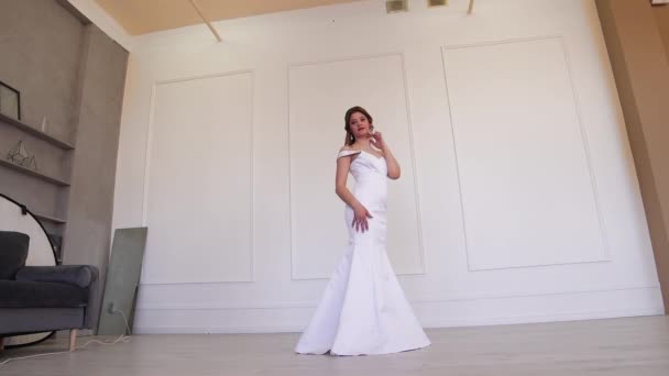 La novia ideal en un vestido blanco posa para el fotógrafo mientras está de pie. — Vídeo de stock