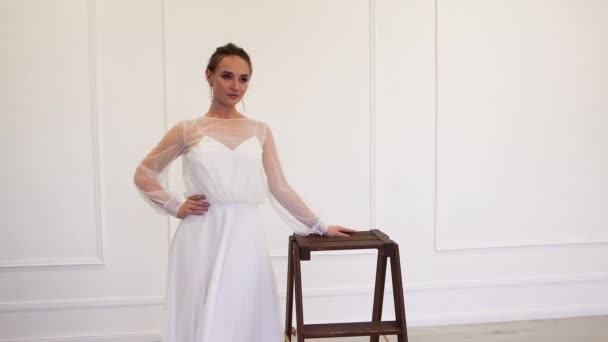Застенчивая модель невесты в белом платье позирует для фотографа — стоковое видео