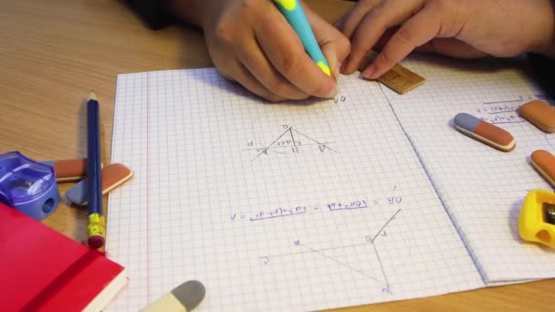 Las manos de un estudiante de secundaria resuelven un problema geométrico en un cuaderno. — Vídeos de Stock