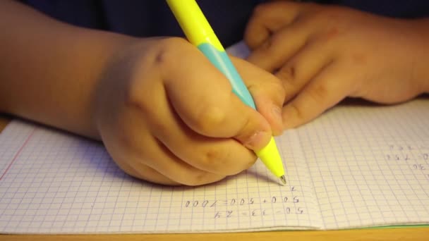 Руки учеников крупным планом тщательно решают математику в блокноте. — стоковое видео