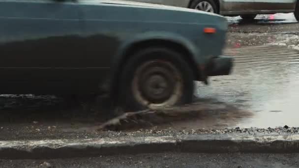 Tiefe Schlaglöcher bei schlechtem Wetter, beschädigte Straßeninfrastruktur. — Stockvideo