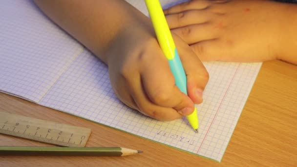 En närbild av elevernas händer löser matematiska exempel i en anteckningsbok. — Stockvideo