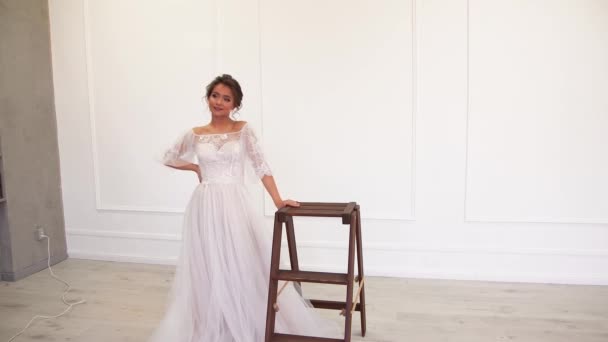 Enamored bride - a model in a white dress posing for a photographer. — Stock Video