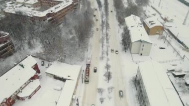 Kar fırtınasından sonra yoğun beyaz karla kaplı düz bir şehirde arabalar..