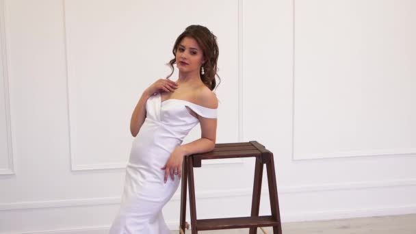 Hermosa novia modelo en un vestido blanco posa para una fotografía — Vídeo de stock