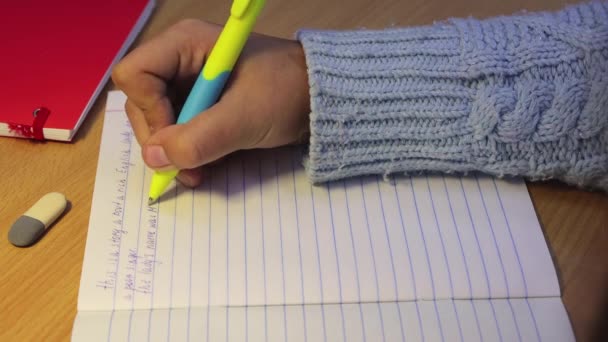 Close-up handen van een middelbare scholier schrijven in het Engels met een pen. — Stockvideo