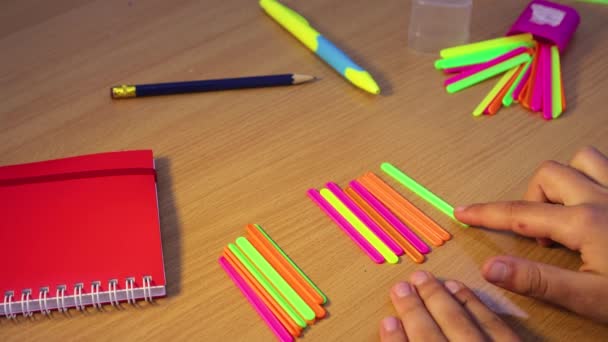 Un estudiante en la escuela aprende aritmética matemática usando palos de conteo. — Vídeos de Stock