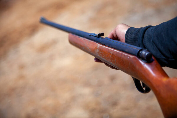 close up of hand holding old gun rifle hunting weapon shotgun