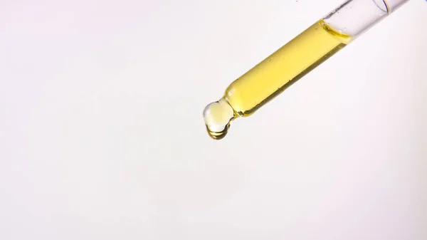 dropper with yellow green oil drop CBD medical chemistry refined extract
