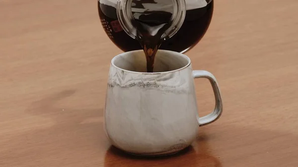 在木桌上的杯子里盛着黑咖啡 — 图库照片