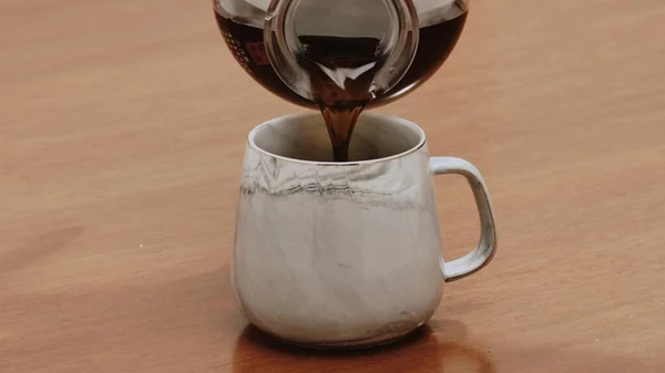 Özel sade kahve, ahşap masada kupada servis ediliyor.