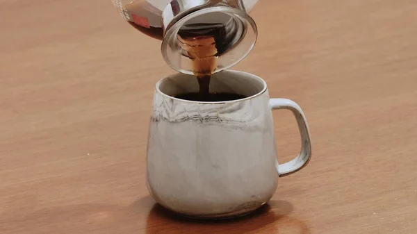 Özel sade kahve, ahşap masada kupada servis ediliyor.