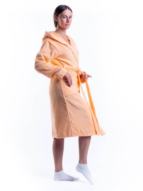 Yüzünde bir gülümseme olan, izole beyaz arka planda, bornozlu bir kadın. Stüdyoda tam gelişimle çekilmiştir..