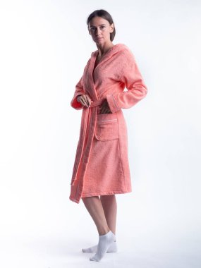 Yüzünde bir gülümseme olan, izole beyaz arka planda, bornozlu bir kadın. Stüdyoda tam gelişimle çekilmiştir..