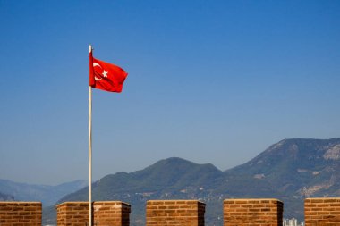 Türkiye 'nin sallanan bayrağı. Alandaki kalenin arka planında, Ich Kale ve dağlar.
