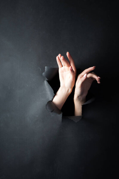 Женские руки, на черном, порванном фоне. Девушка в нижнем белье позирует перед камерой.