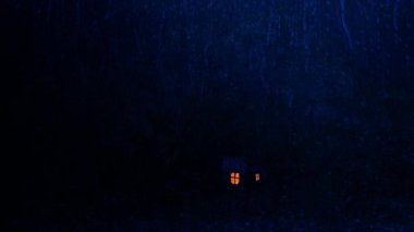 Geceleri camlara sağanak yağmur yağar, kır evinin pencerelerinden ışıklar yanar.