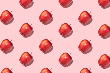 Pembe arka planda kırmızı elmalar. Şablon, üst manzara, düz yatış.