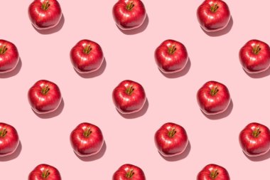 Pembe arka planda kırmızı elmalar. Şablon, üst manzara, düz yatış.