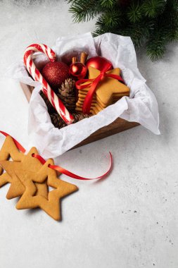 Zencefilli çörek, kırmızı toplar ve tahta kutuda lolipoplar. Noel ya da yeni yıl konsepti. Ev yapımı kurabiyeler. Fırın hediyesi. Hamur işi hediyesi.