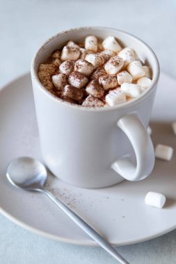 Gri masadaki seramik bardakta kremalı sıcak kakao. Kış ya da sonbahar konsepti. En düşük tasarım.