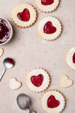 Linzer cookies in shape of heart with jam on light background. Mother's day, Women's day, Valentine's day. Homemade present. Copy space, top view.