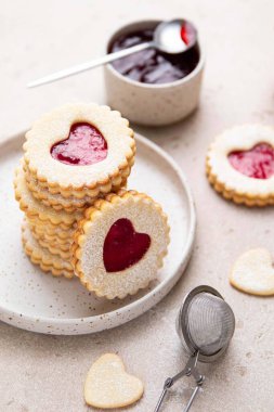 Linzer cookies in shape of heart with jam on light background. Mother's day, Women's day, Valentine's day. Homemade present. Selective focus.