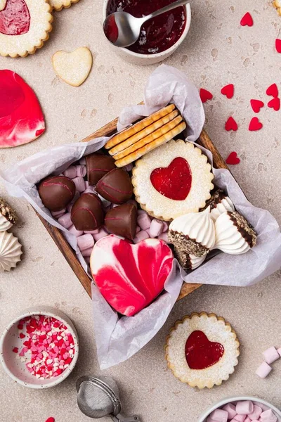 Valentines Day sweets and cookies in wooden box. Chocolate, candy, meringue, marshmallow, linzer cookies, gingerbread. Mother\'s day, Women\'s day. Homemade present.