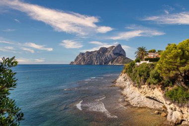 Calpe 'de bir koy. Arka planda Penon ifach taşı var. Calpe şehrindeki Akdeniz sahili manzarası. Valencia 'nın Alicante, İspanya' da bulunan sahil kenti.