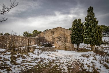 Karlı bukolik manzara. Ağaçlı harap olmuş eski bir evin resimli görüntüsü.