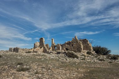 Kırsal evi harabeye çeviriyor, mavi gökyüzünün altındaki bir vadide zamanın geçişi tarafından hasar görmüş ve terk edilmiş.