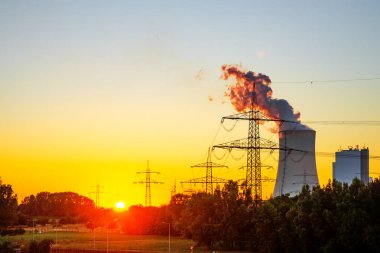 Gün batımında nehirde kömürle çalışan elektrik santrali