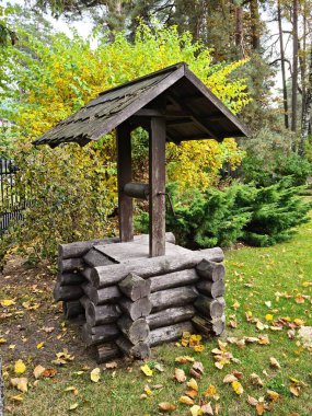 Köyün dışında güçlü bir çatısı olan eski bir ahşap kuyu.