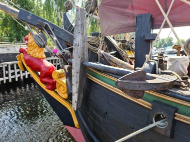 Paslı çapa ahşap bloklar ve eski bir yelkenli gemisinin donanımı arasında demirli..
