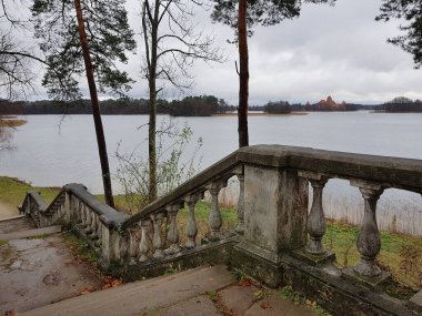 An old stone staircase on the lake shore and a panorama with a view of the Trakai Island Castle in Lithuania on November 18, 2018.