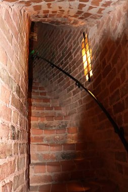 An old narrow red brick staircase going up inside the tower.