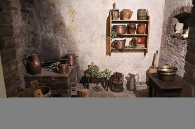 In the village room there are old wooden buckets, old copper dishes and clay jugs.