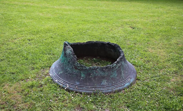 Part of a broken church bell on a green lawn in the courtyard of the Mitava Palace in the Latvian city of Jelgava on May 15, 2020.